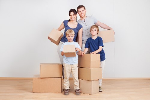 Moving crew handling boxes and furniture on a central London residential street