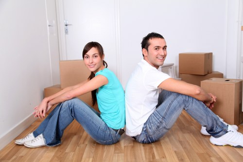 Professional movers carrying office items through a period-style building entrance