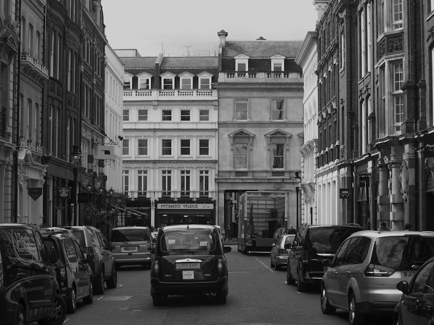 A white moving van with the logo 'WEBSTAR' parked on a street in Belgravia, with its rear door open revealing an empty interior equipped with a hand truck, a small blue plant lift, and packing materia