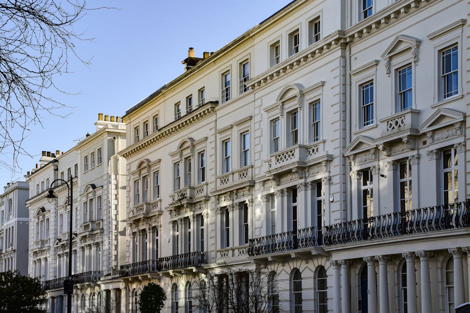 A multi-storey Victorian-style building with a red-brick façade featuring large bay windows, decorative stonework, and a central entrance with steps leading up to a white door. The building has sever